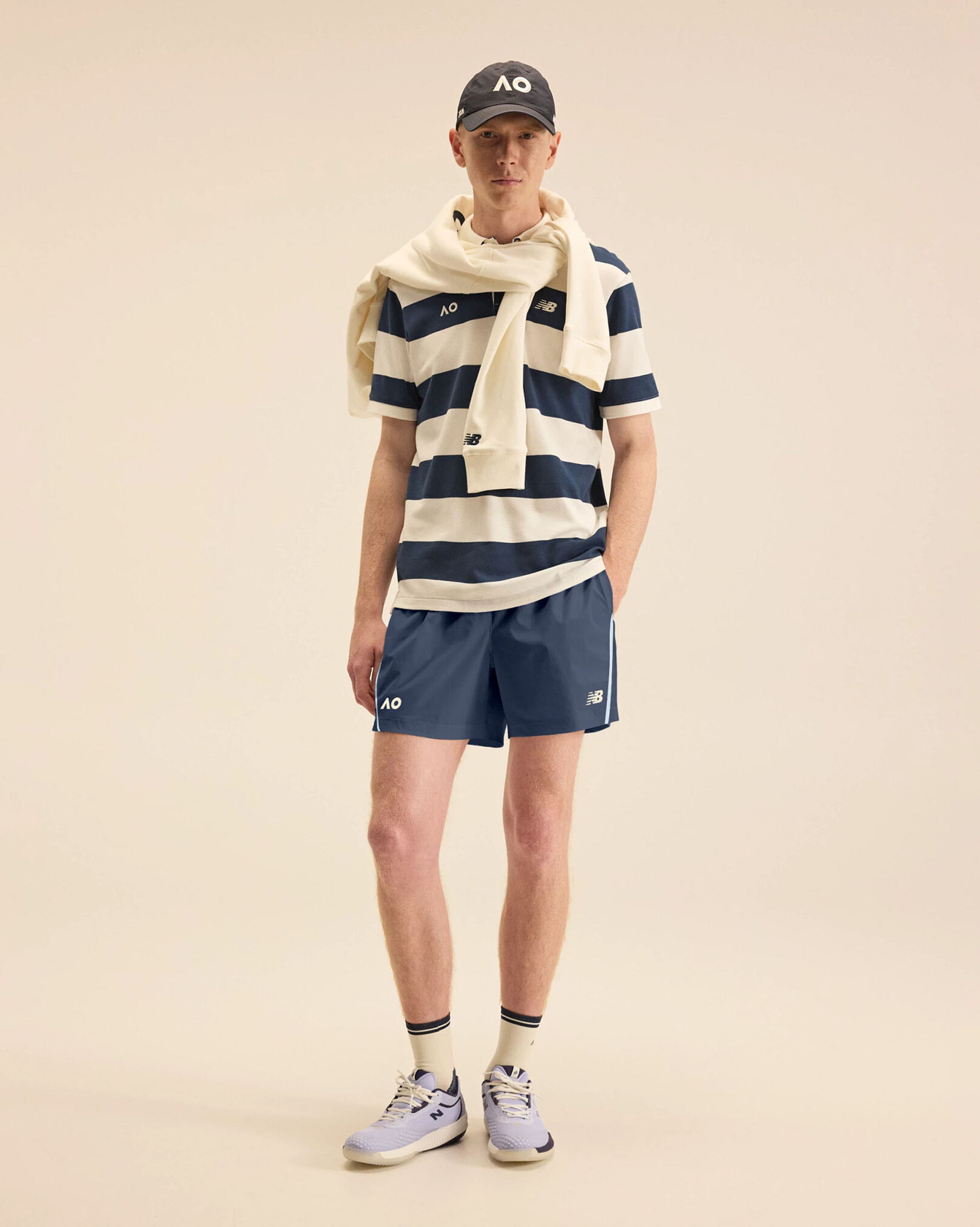 A person standing against a tan studio backdrop.