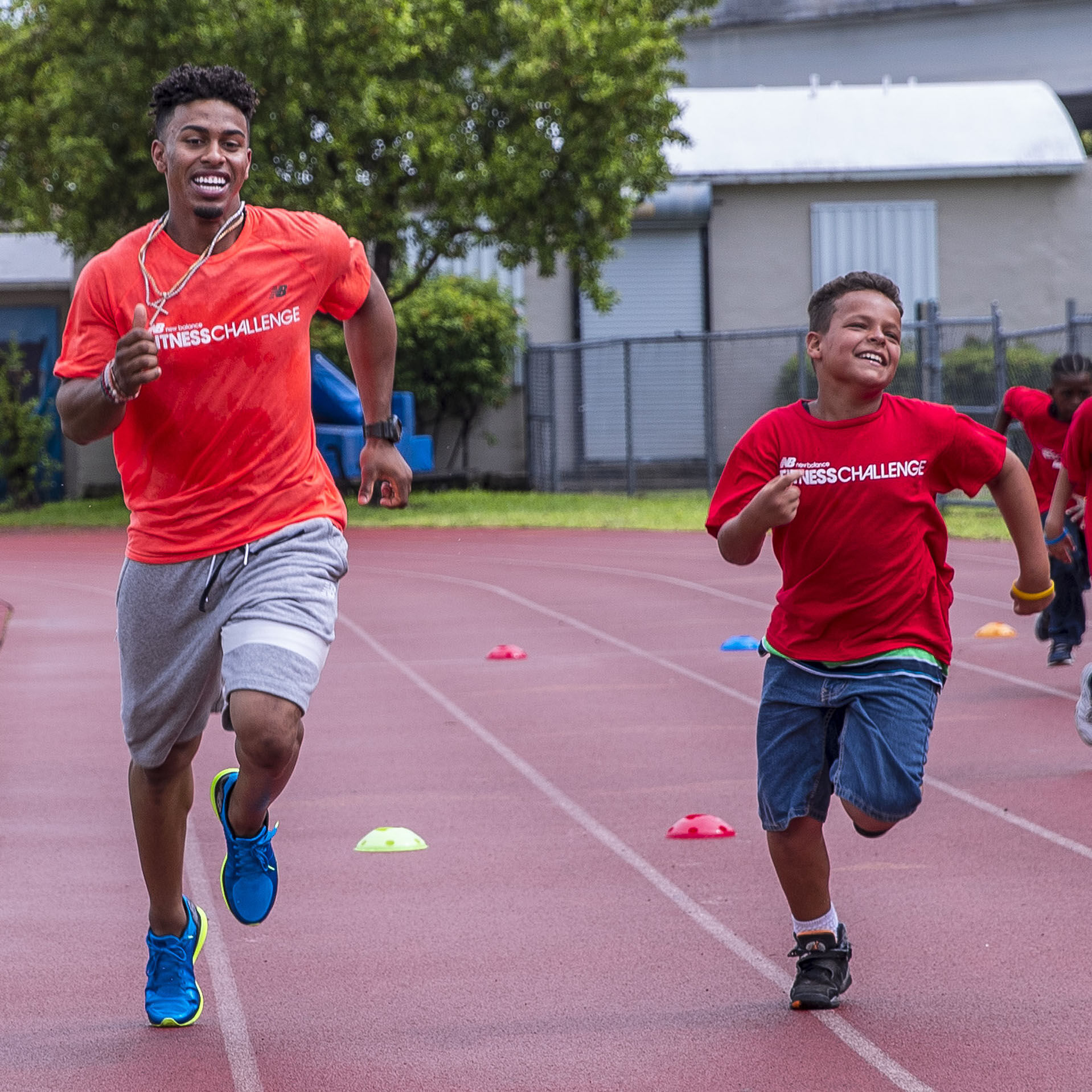 Francisco Lindor smiling and running on outdoor track with kids