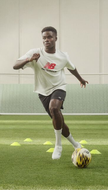 Soccer player dribbling through cones on a soccer field